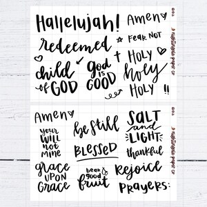 Pu&ograve; includere: Foglio di adesivi bianco con frasi ispiratrici scritte a mano in nero, tra cui "Hallelujah!", "Amen", "Redeemed", "Child of God", "God is Good", "Holy", "Be Still" e "Blessed". Il foglio ha un motivo a griglia.