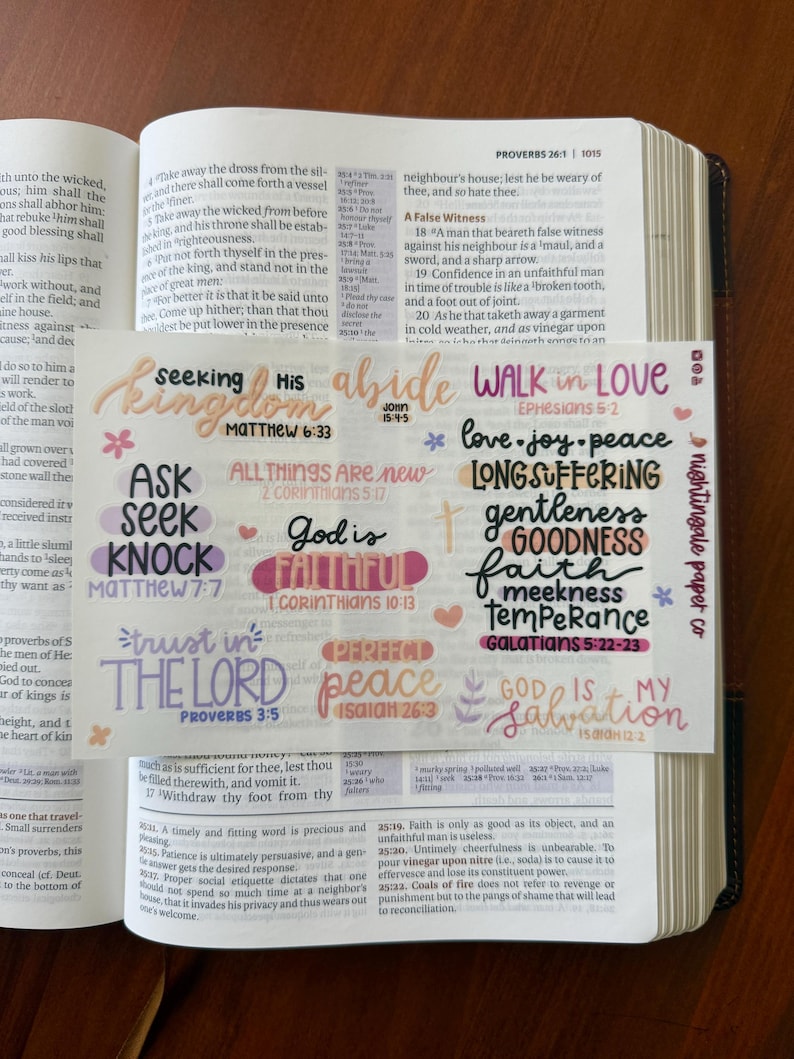 Pu&ograve; includere: Un set di adesivi colorati con versetti biblici su un libro. Gli adesivi presentano frasi come "Seeking His Kingdom" e "Walk in Love" in vari caratteri e colori. Gli adesivi sono progettati per il journaling e l'artigianato religioso.