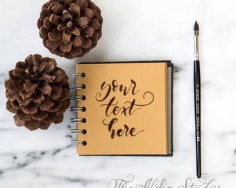 Marble and pinecones flatlay / Kraftpaper journal mockup / Instagram lettering background with brush and little journal