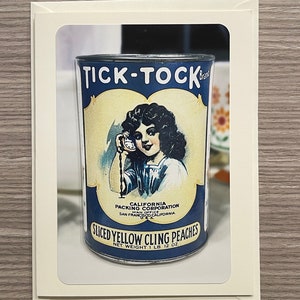 May include: A vintage can of Tick-Tock brand sliced yellow cling peaches. The can is blue and white with a picture of a girl holding a clock. The text on the can reads "Tick-Tock", "California Packing Corporation", "San Francisco California", "Sliced Yellow Cling Peaches", and "Net Weight 1 lb 12 oz".