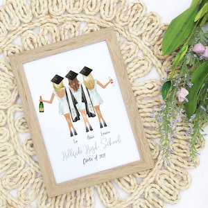May include: A framed watercolor illustration of three friends in graduation caps and gowns, holding champagne glasses. The text below reads "Hillside High School Class of 2023".