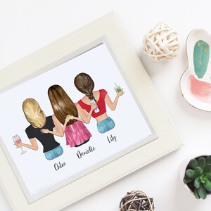 May include: A framed print featuring an illustration of four women, each with different hairstyles and holding drinks. The print is in a white frame, and the scene is decorated with a cactus-shaped dish, a small succulent, and decorative spheres.