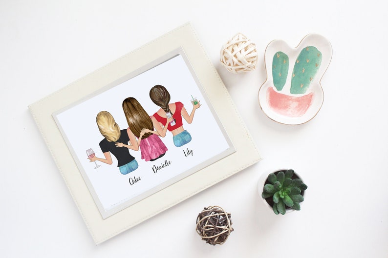 May include: A framed print featuring an illustration of four women, each with different hairstyles and holding drinks. The print is in a white frame, and the scene is decorated with a cactus-shaped dish, a small succulent, and decorative spheres.