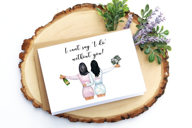 May include: A white card with the text "I can't say 'I do' without you!" and an illustration of two women in robes, one holding a bottle of champagne and the other holding a bouquet of flowers.