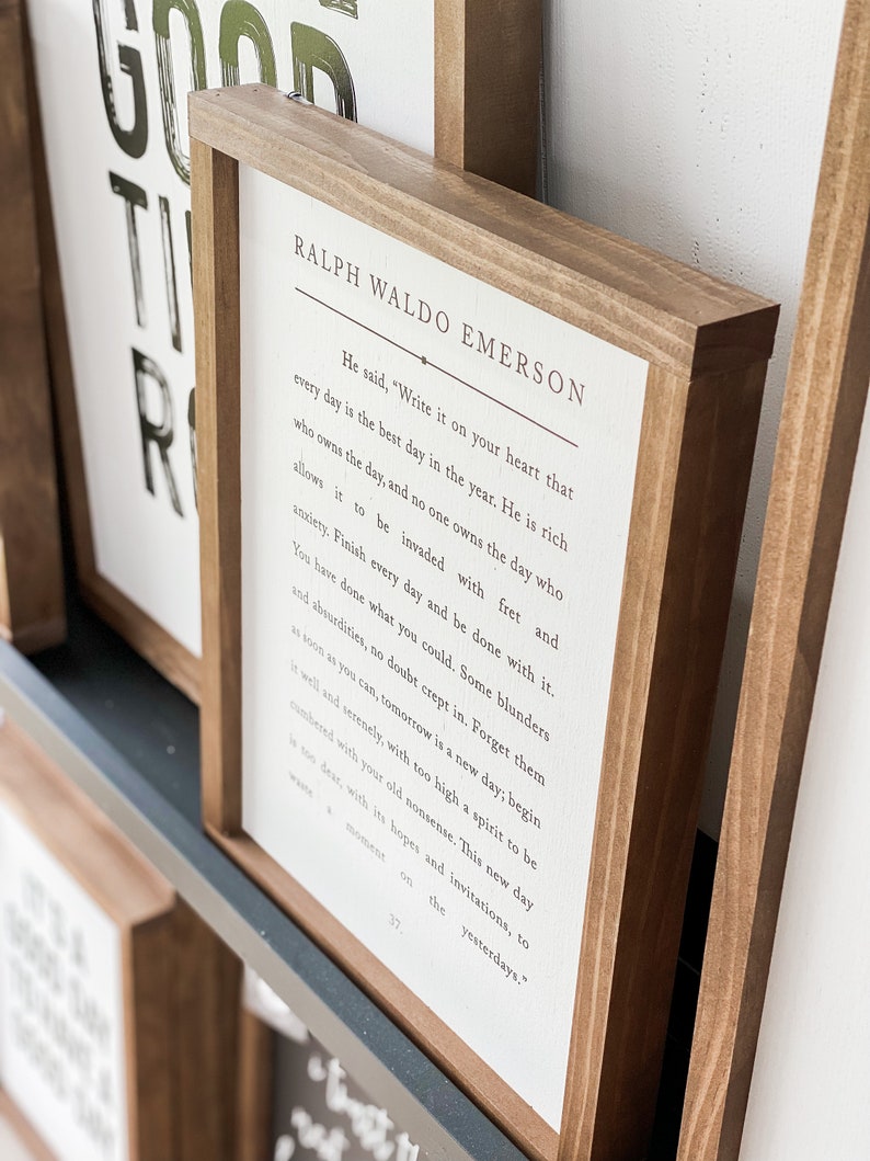 Pode incluir: Uma placa de madeira enquadrada com fundo branco e texto preto. O texto &eacute; uma citaat de Ralph Waldo Emerson que diz: "Ele disse: 'Escreva isso em seu cora&ccedil;&atilde;o que cada dia &eacute; o melhor dia do ano. Ele &eacute; rico quem possui o dia, e ningu&eacute;m possui o dia que permite que seja invadido por preocupa&ccedil;&otilde;es e ansiedade. Termine cada dia e fa&ccedil;a as pazes com ele. Voc&ecirc; fez o que p&ocirc;de. Sem d&uacute;vida, alguns erros e absurdos se infiltraram. Esque&ccedil;a-os o mais r&aacute;pido poss&iacute;vel, amanh&atilde; &eacute; um novo dia; comece-o bem e serenamente, com um esp&iacute;rito muito elevado para ser sobrecarregado por suas velhas bobagens. Este novo dia &eacute; muito precioso, com suas esperan&ccedil;as e convites, para perder um momento nos dias passados.'"