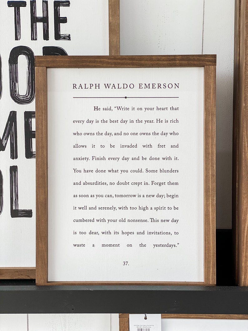Pode incluir: Um letreiro de madeira enquadrado com fundo branco e texto preto. A cita&ccedil;&atilde;o &eacute; de Ralph Waldo Emerson e diz: "Ele disse: 'Escreva isso em seu cora&ccedil;&atilde;o que cada dia &eacute; o melhor dia do ano. &Eacute; rico quem possui o dia, e ningu&eacute;m possui o dia que permite que seja invadido pela preocupa&ccedil;&atilde;o e ansiedade. Termine cada dia e fa&ccedil;a as pazes com ele. Voc&ecirc; fez o que p&ocirc;de. Sem d&uacute;vida, alguns erros e absurdos se infiltraram. Esque&ccedil;a-os o mais r&aacute;pido poss&iacute;vel, amanh&atilde; &eacute; um novo dia; comece bem e serenamente, com um esp&iacute;rito muito elevado para ser sobrecarregado por suas velhas bobagens. Este novo dia &eacute; muito precioso, com suas esperan&ccedil;as e convites, para perder um momento nos dias passados.'" O n&uacute;mero 37 est&aacute; impresso na parte inferior do letreiro.