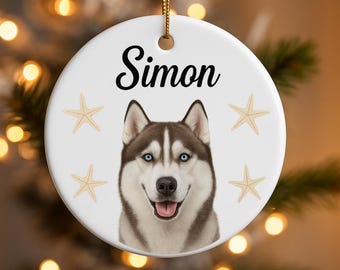 May include: White ceramic ornament with a smiling Siberian Husky dog portrait, blue eyes, and the name "Simon" in black script. Features starfish accents and a gold string for hanging.