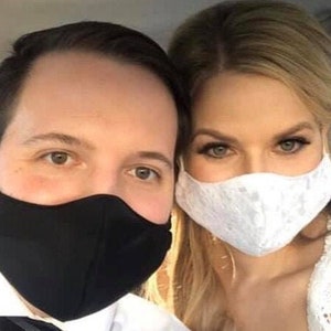 Puede incluir: Una pareja usando mascarillas. La mujer lleva una mascarilla de encaje blanco y el hombre lleva una mascarilla negra.