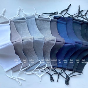 Puede incluir: Diez mascarillas faciales en varios colores y tejidos, incluyendo blanco, plateado, gris jaspeado, gris claro, gris medio, carb&oacute;n, traje azul marino, sarga azul marino, azul marino oscuro, traje negro y negro espiga.