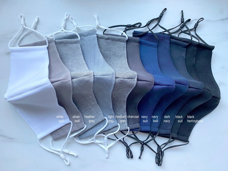 Puede incluir: Diez mascarillas faciales en varios colores y tejidos, incluyendo blanco, plateado, gris jaspeado, gris claro, gris medio, carb&oacute;n, traje azul marino, sarga azul marino, azul marino oscuro, traje negro y negro espiga.