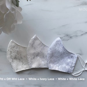 Puede incluir: Tres mascarillas blancas con diferentes patrones de encaje. Las mascarillas est&aacute;n hechas de tela blanca con una superposici&oacute;n de encaje. Los patrones de encaje son blanco roto, marfil y blanco. El texto "Off Wht + Off Wht Lace", "White + Ivory Lace" y "White + White Lace" est&aacute; escrito debajo de las mascarillas.
