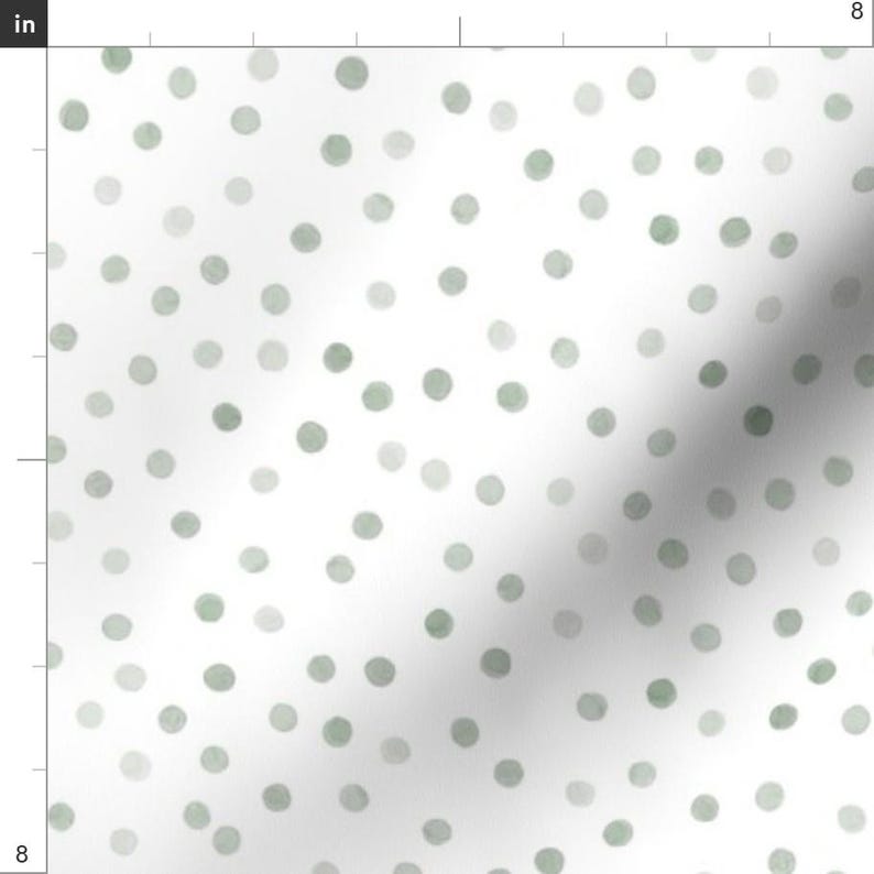 May include: White fabric with a repeating pattern of soft green and gray polka dots. The dots vary in size and shade, creating a watercolor effect. The design is simple and elegant, suitable for various craft projects.