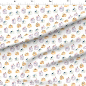 K&ouml;nnte beinhalten: Ein wei&szlig;er Stoff mit einem sich wiederholenden Muster aus Aquarell-K&uuml;rbissen in Orange-, Helllila- und Wei&szlig;t&ouml;nen, die jeweils mit kleinen blauen und rosa Blumenakzenten verziert sind, neben einem Lineal bis 100 cm.
