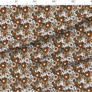 May include: A white fabric with a repeating pattern of brown, orange, and pink flowers. The flowers are arranged in a random pattern and are surrounded by green leaves.