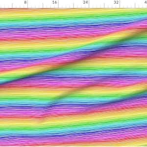 May include: A colourful rainbow striped fabric with a wavy pattern. The fabric is white with thin lines of red, orange, yellow, green, blue, indigo, and violet.
