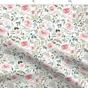 May include: White fabric with a watercolor floral pattern. The design features pink roses, green leaves, and small blue flowers. The pattern is dense and covers the entire surface, creating a romantic and natural aesthetic.