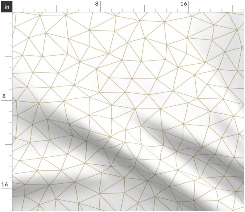 Op de afbeelding: Witte stof met een geometrisch patroon van dunne gouden lijnen die driehoeken vormen.