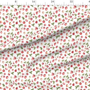 May include: A white fabric with a repeating pattern of red and green watercolor strawberries. The strawberries are scattered randomly across the fabric.