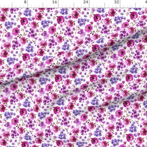 Op de afbeelding: Een witte stof met een herhalend patroon van roze en paarse aquarelbloemen. De bloemen zijn willekeurig gerangschikt en omgeven door groene bladeren.