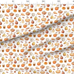 May include: White fabric featuring a repeating pattern of autumnal illustrations. The design includes pumpkins, pie slices, donuts, coffee cups, and cinnamon sticks in shades of orange, brown, and beige.