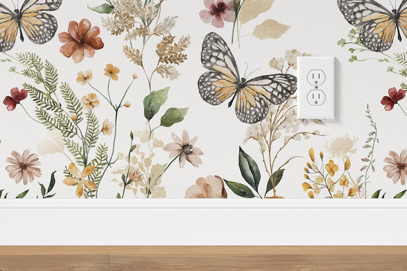 K&ouml;nnte beinhalten: Eine wei&szlig;e Wand mit einer floralen Tapete mit Schmetterlingen, Bl&auml;ttern und Blumen in Braun-, Gelb- und Rosat&ouml;nen. Eine wei&szlig;e Steckdose ist an der Wand sichtbar.