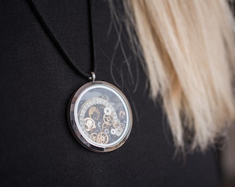 montre engrenages de mouvement pendentif, vintage steampunk, pendentif rond rétro antique montre à la main dans un cadre de couleur argent
