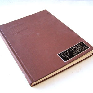 Könnte beinhalten: Ein braunes Hardcover-Buch mit dem Titel "The History of the United States" auf dem vorderen Einband. Das Buch hat einen schwarzen und silbernen Aufkleber auf dem hinteren Einband mit dem Text "E. Lewis Cook & Associates 1823 Carter Street Chattanooga, Tenn. 37408".