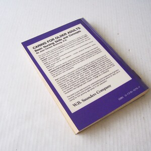 May include: A book titled "Caring for Older Adults" with the subtitle "Basic Nursing Skills and Concepts" by Joan Carson Breitung, R.N. The cover is purple with white text. The book is from W.B. Saunders Company.