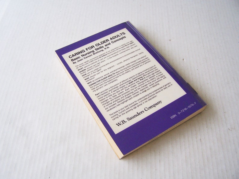 May include: A book titled "Caring for Older Adults" with the subtitle "Basic Nursing Skills and Concepts" by Joan Carson Breitung, R.N. The cover is purple with white text. The book is from W.B. Saunders Company.