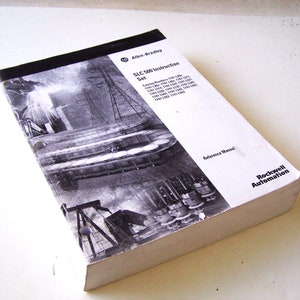 Puede incluir: Un manual de instrucciones blanco y negro para el conjunto de instrucciones SLC-500. El manual es de Allen-Bradley y Rockwell Automation. La portada presenta una foto en blanco y negro de equipos industriales.