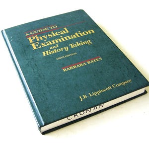 May include: A teal-colored book titled "A Guide to Physical Examination and History Taking" with gold lettering. The author's name, Barbara Bates, and the publisher, J.B. Lippincott Company, are also visible.
