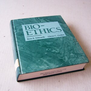 Puede incluir: Un libro de tapa dura titulado "BIO-ETHICS" con una cubierta verde azulado con diseño de mármol. Los nombres de los autores, Rem B. Edwards y Glenn C. Graber, están impresos debajo del título. Una etiqueta de biblioteca está adherida al lomo.