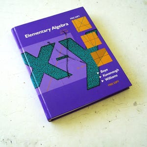 May include: A purple hardback textbook titled Elementary Algebra by Boye, Kavanaugh, and Williams. The cover features a large teal X-Y graphic, three orange square diagrams with lines, and the text FREE COPY printed in white at the top and bottom.