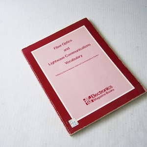 May include: A red book with the title "Fiber Optics and Lightwave Communications Vocabulary" by Dennis Bodson. The book is published by Electronics Magazine Books.