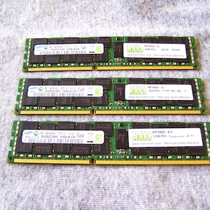 May include: Three green rectangular RAM memory modules arranged horizontally. Each module features black integrated circuit chips, a gold-plated connector edge, and two white labels with black text including the brand name NEMIX RAM.