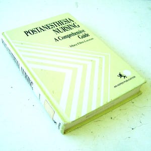 Puede incluir: Un libro de tapa dura titulado Postanesthesia Nursing: A Comprehensive Guide de Mary Ellen Luczun. La cubierta es de color amarillo pálido con rayas diagonales blancas, texto en negro y un pequeño logotipo negro con el texto AN ASPEN PUBLICATION.