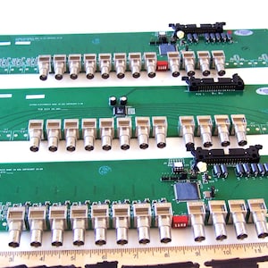 May include: Three green circuit boards with rows of silver BNC connectors. The boards are labeled "EXTRON ELECTRONICS CORP. 500 LAKESIDE DR. COVINGTON, GA 30014".