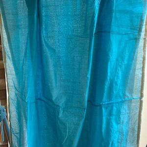 May include: A teal blue fabric with gold trim. The fabric is hanging on a rod.