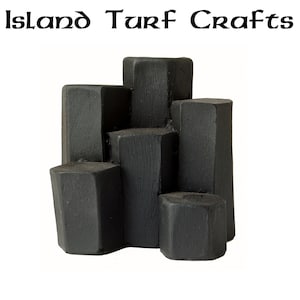 Può includere: Blocchi neri di forma geometrica impilati uno sopra l'altro. I blocchi sono fatti di un materiale scuro e hanno una texture ruvida. I blocchi sono disposti in uno schema casuale. Island Turf Crafts è scritto in testo nero nella parte superiore dell'immagine.