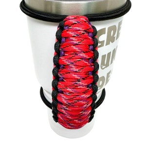 May include: Red, black, and purple paracord handle for a travel mug. The handle is wrapped in a camouflage pattern.