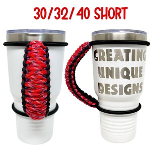 May include: Two white tumblers with black lids and black rubber bands. The tumbler on the right has the text "Creating Unique Designs" printed on it. Both tumblers have a red, black, and purple paracord handle.