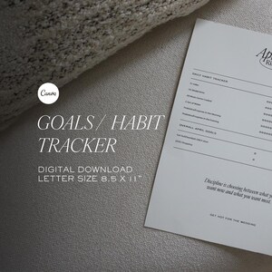 Pu&ograve; includere: Un tracker delle abitudini bianco in formato lettera con il testo "April Rituals" e "Goals/Habit Tracker". Il tracker include sezioni per gli obiettivi giornalieri e generali, con una citazione in basso. La carta misura 21,6 x 27,9 cm.