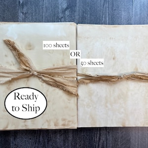 May include: Two stacks of aged paper sheets, bound with tan fabric ribbon. The text on the image reads "100 sheets OR 50 sheets" and "Ready to Ship". The paper has a vintage, stained appearance.