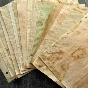 May include: A collection of aged graph paper sheets in various shades of brown, beige, and green. The paper has a vintage appearance with grid lines in red, brown, and green. Some sheets have three-hole punches for binding.
