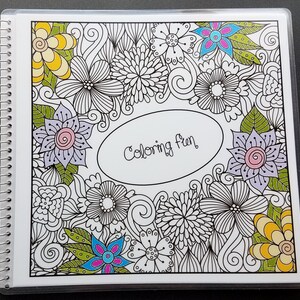 May include: A coloring book with a white cover and a black and white illustration of flowers and swirls. The title "Coloring Fun" is written in black cursive on the cover.