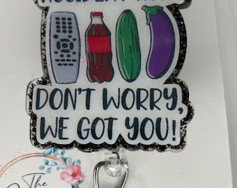 May include: A black and white glitter badge holder with the text "Accident huh? Don't worry, we got you!" and a graphic of a remote control, a bottle of soda, a cucumber, and an eggplant. The badge holder has a clear plastic clip.