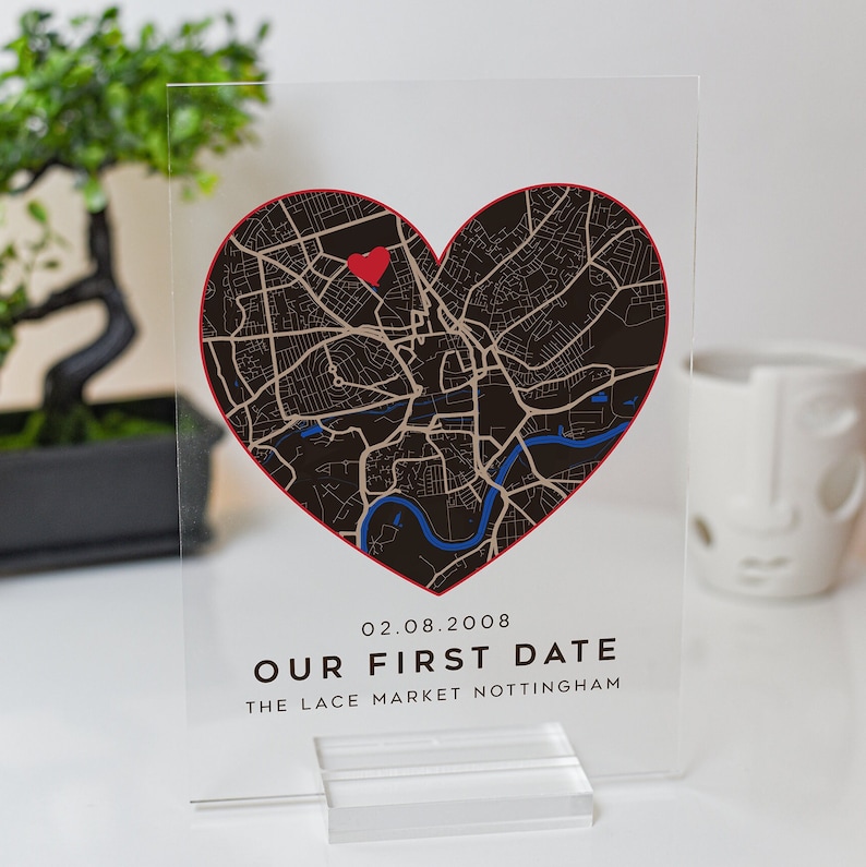 May include: A clear acrylic plaque with a black and white map of a city in the shape of a heart. A red heart is placed on the map. The text "02.08.2008 OUR FIRST DATE THE LACE MARKET NOTTINGHAM" is printed below the map.