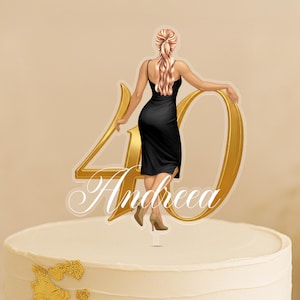 May include: Cake decoration showing a woman in a black dress, next to a gold number 40. The name "Andreea" is written in cursive script below the number. The topper is placed on a white cake with gold accents.