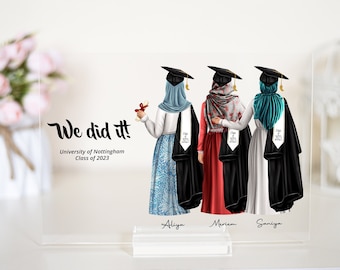 May include: Three women in graduation caps and gowns stand together, arms around each other. They are wearing headscarves in blue, red, and teal. The text "We did it!" is at the top of the image, followed by "University of Nottingham Class of 2023". The women's names are written below them: Aliya, Meriem, and Saniya.
