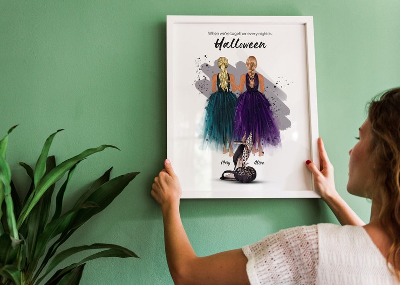 Może przedstawiać: Biały wydruk w ramie z akwarelową ilustracją dw&oacute;ch kobiet w fioletowych i turkusowych sukienkach. Tekst "When we're together every night is Halloween" znajduje się na g&oacute;rze wydruku. Nazwy "Mary" i "Alice" są napisane pod kobietami.